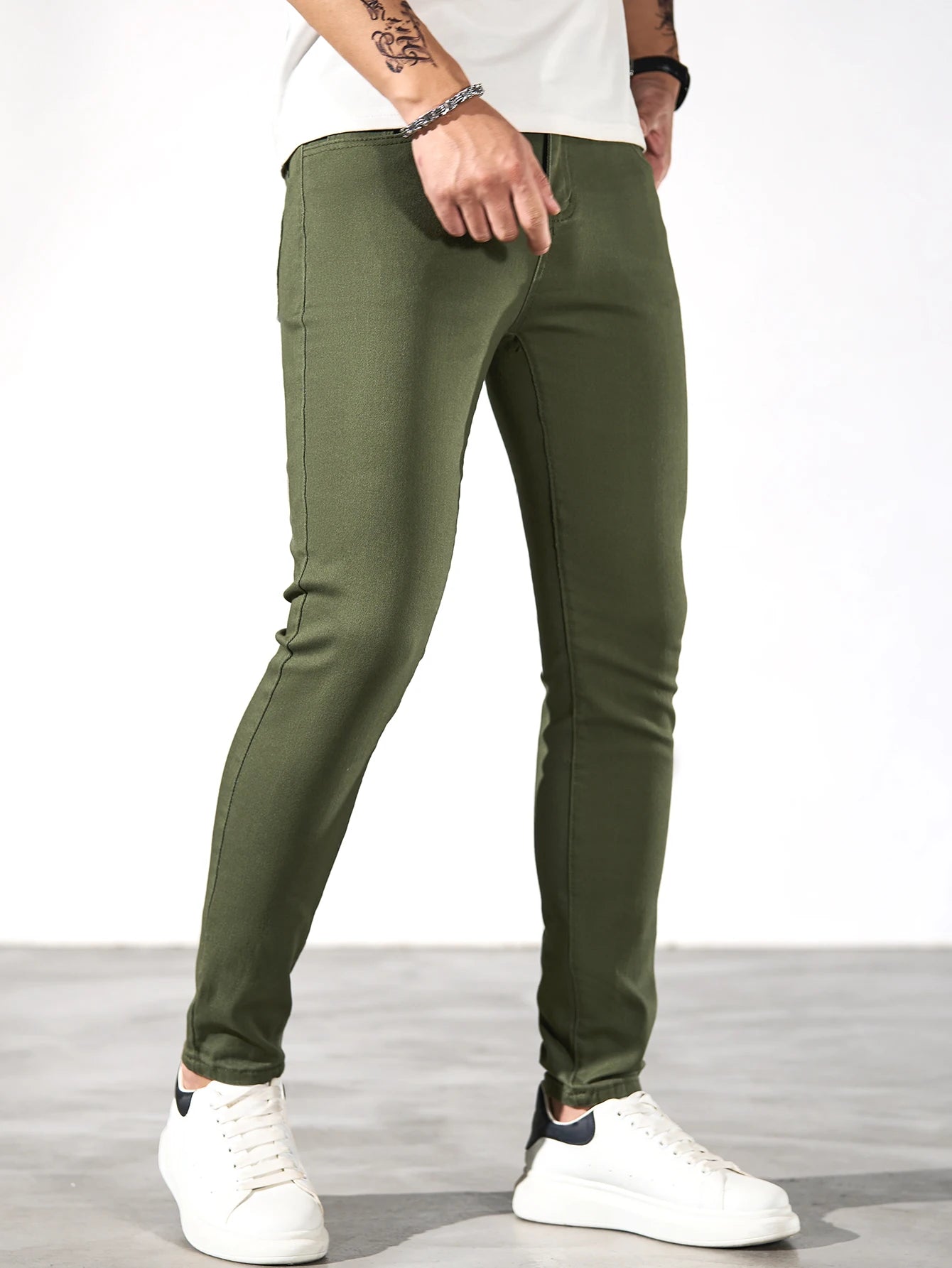 Fashionable men's skinny jeans. Army green straight skinny trousers. Casual street men's jeans.