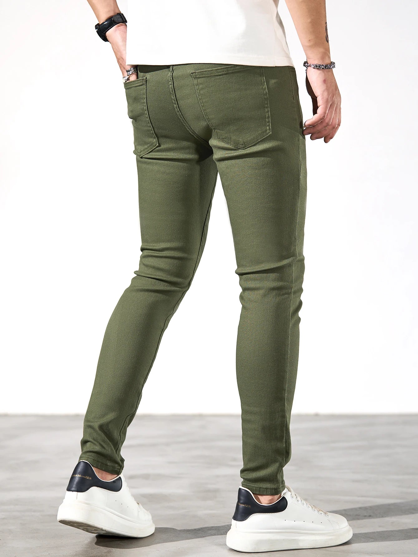 Fashionable men's skinny jeans. Army green straight skinny trousers. Casual street men's jeans.